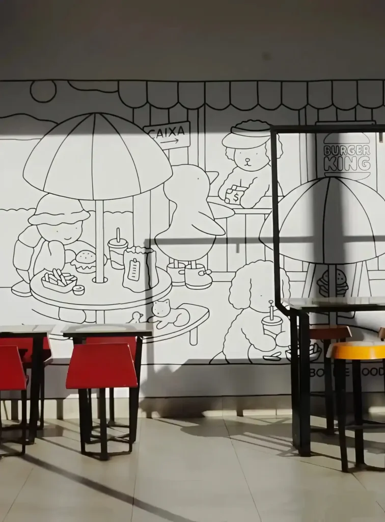 Espaço interno do Burger King preparado para oficinas Bobbie Goods, com mesas e materiais de arte para atividades infantis.