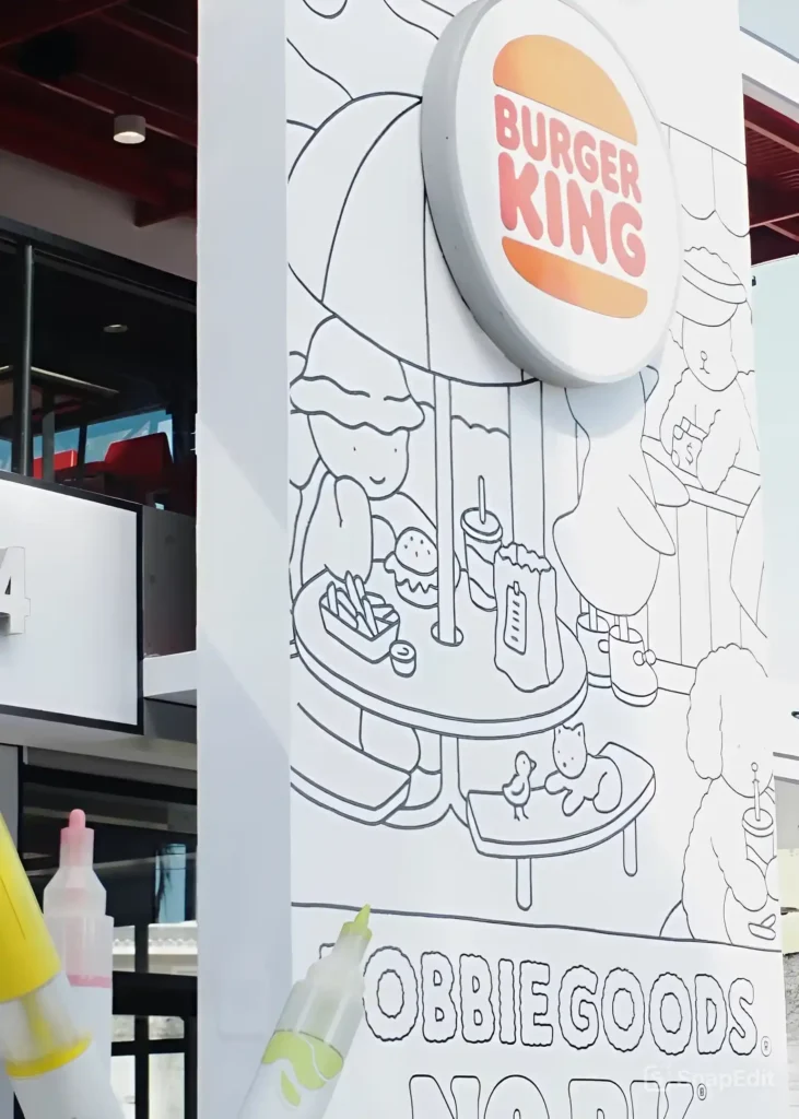 Painel decorativo do Burger King com ilustrações coloridas e estilosas da marca Bobbie Goods, exibindo personagens e elementos artísticos.