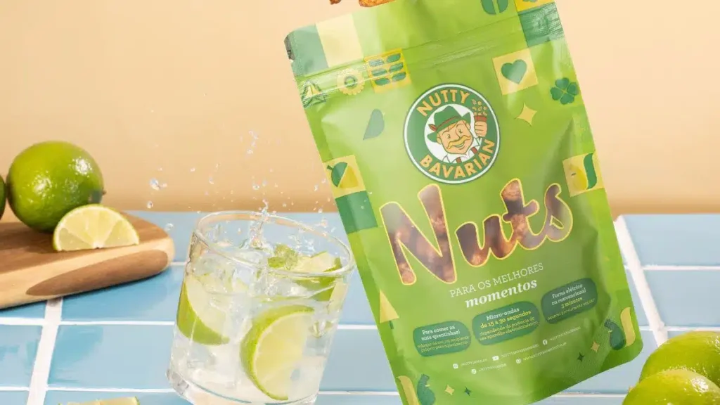 Snack Nutty Citrus da Nutty Bavarian em destaque: mistura de amendoim e castanhas de caju glaceadas com tiras de limão siciliano cristalizado sobre fundo claro.