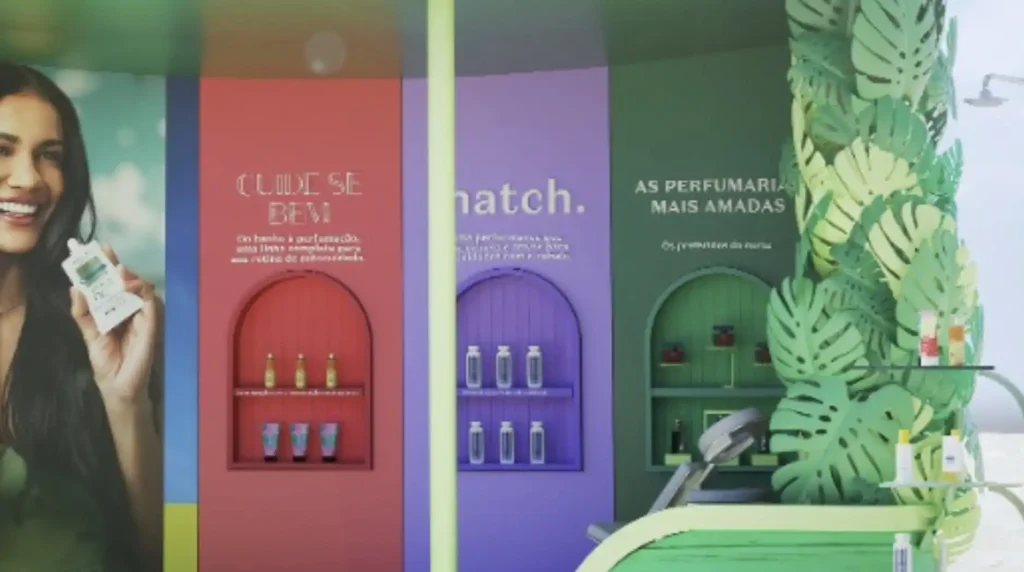 Uma imagem publicitária com três seções verticais, cada uma apresentando produtos de beleza.

À esquerda, uma seção azul-esverdeada mostra o rosto sorridente de uma mulher com cabelos escuros, segurando um pequeno frasco branco.

No centro, uma seção rosa-avermelhada exibe prateleiras arqueadas com pequenos frascos e tubos de produtos para o cabelo. Acima das prateleiras, o texto "CUIDE-SE BEM" está escrito.

À direita do centro, uma seção roxa também apresenta prateleiras arqueadas com vários frascos idênticos de produtos brancos. Acima das prateleiras, a palavra "match." é visível.

À direita, uma seção verde escuro, adornada com grandes folhas tropicais de papel, exibe mais prateleiras com diferentes produtos de beleza. Acima das prateleiras, lê-se "AS PERFUMARIAS MAIS AMADAS". No canto superior direito, um chuveiro de praia é visível.