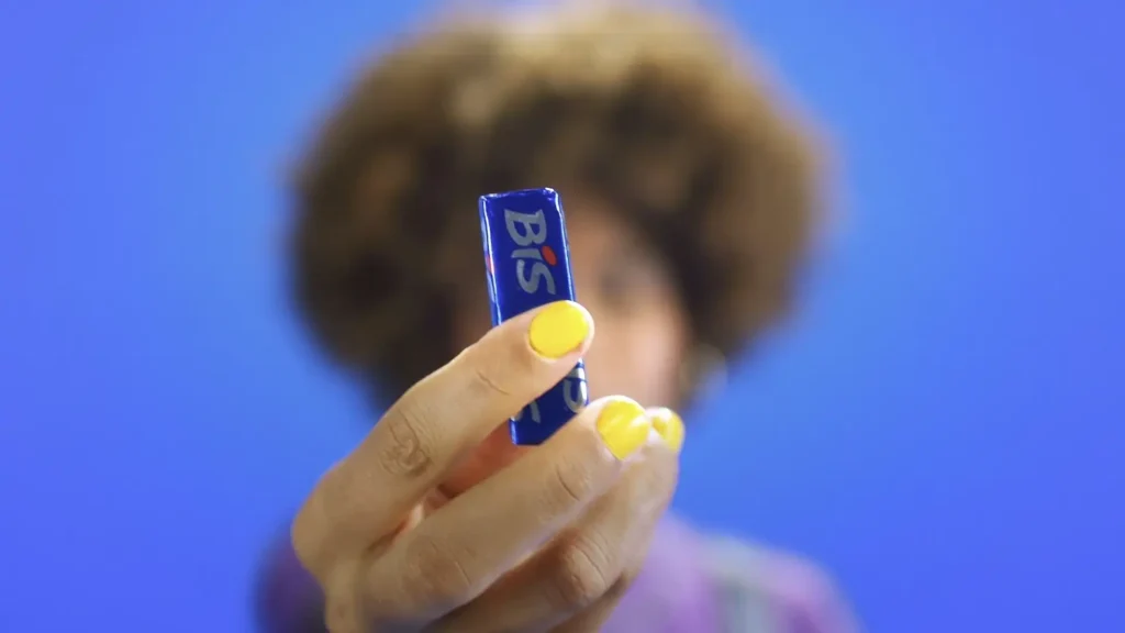 Mulher segurando um chocolate BIS na mão