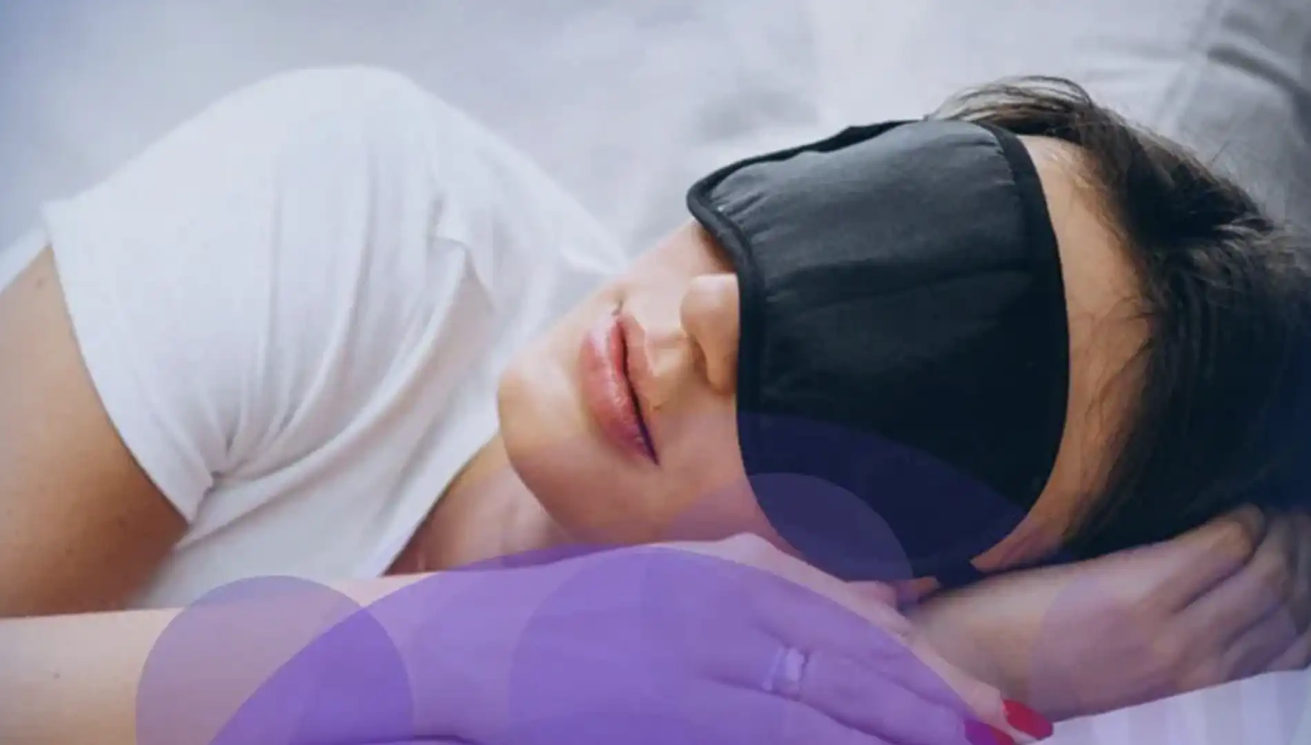 Mulher dormindo com máscara de dormir preta.