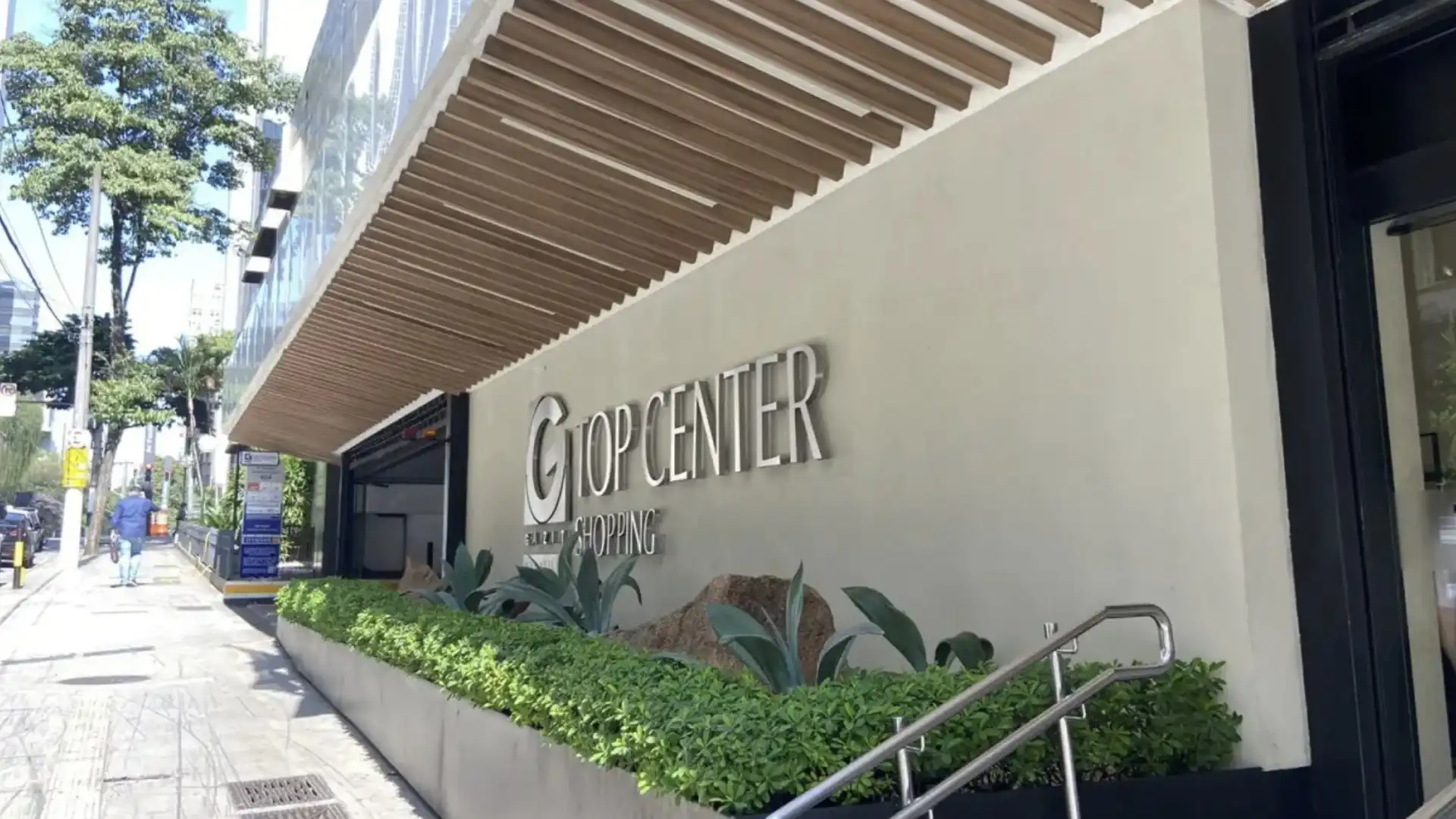 A fachada do Shopping Top Center, com a placa do nome do shopping e o letreiro "Shopping" logo abaixo.