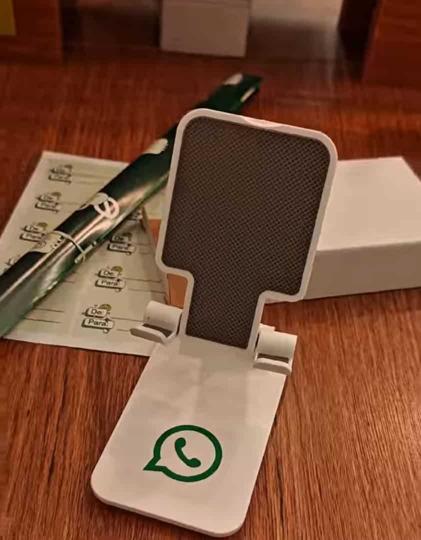 Suporte de celular dobrável, branco e cinza, com o logotipo verde do WhatsApp.