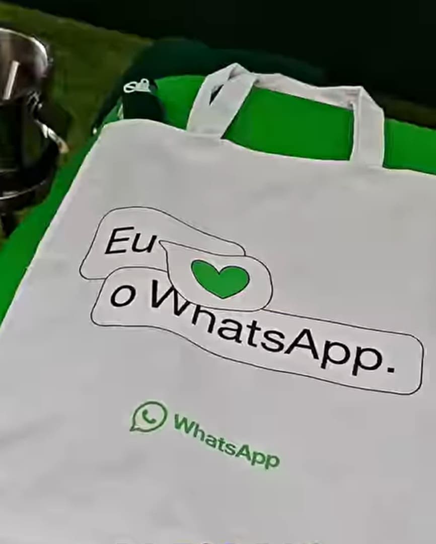 Ecobag branca com a frase "Eu amo WhatsApp" em verde e preto, com um coração verde no lugar de "amo".