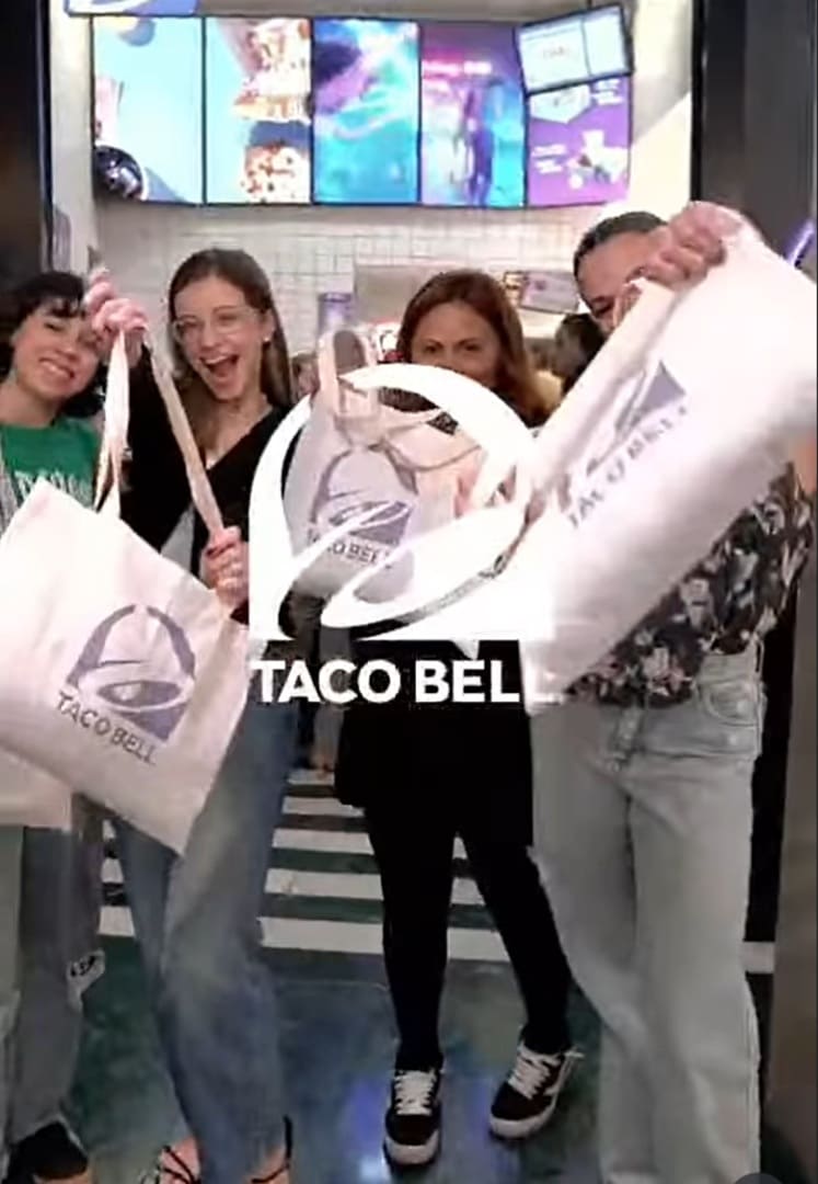 Pessoas celebrando com kits de inauguração da Taco Bell.