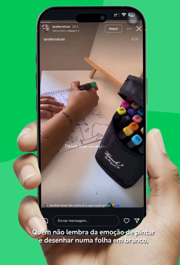 Mãos desenhando em um caderno com canetas marcadoras coloridas ao lado.