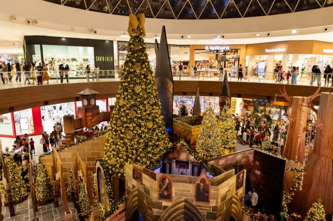 Decoração de Natal temática de Harry Potter em um shopping de Salvador, com uma grande árvore iluminada e réplicas do castelo de Hogwarts.