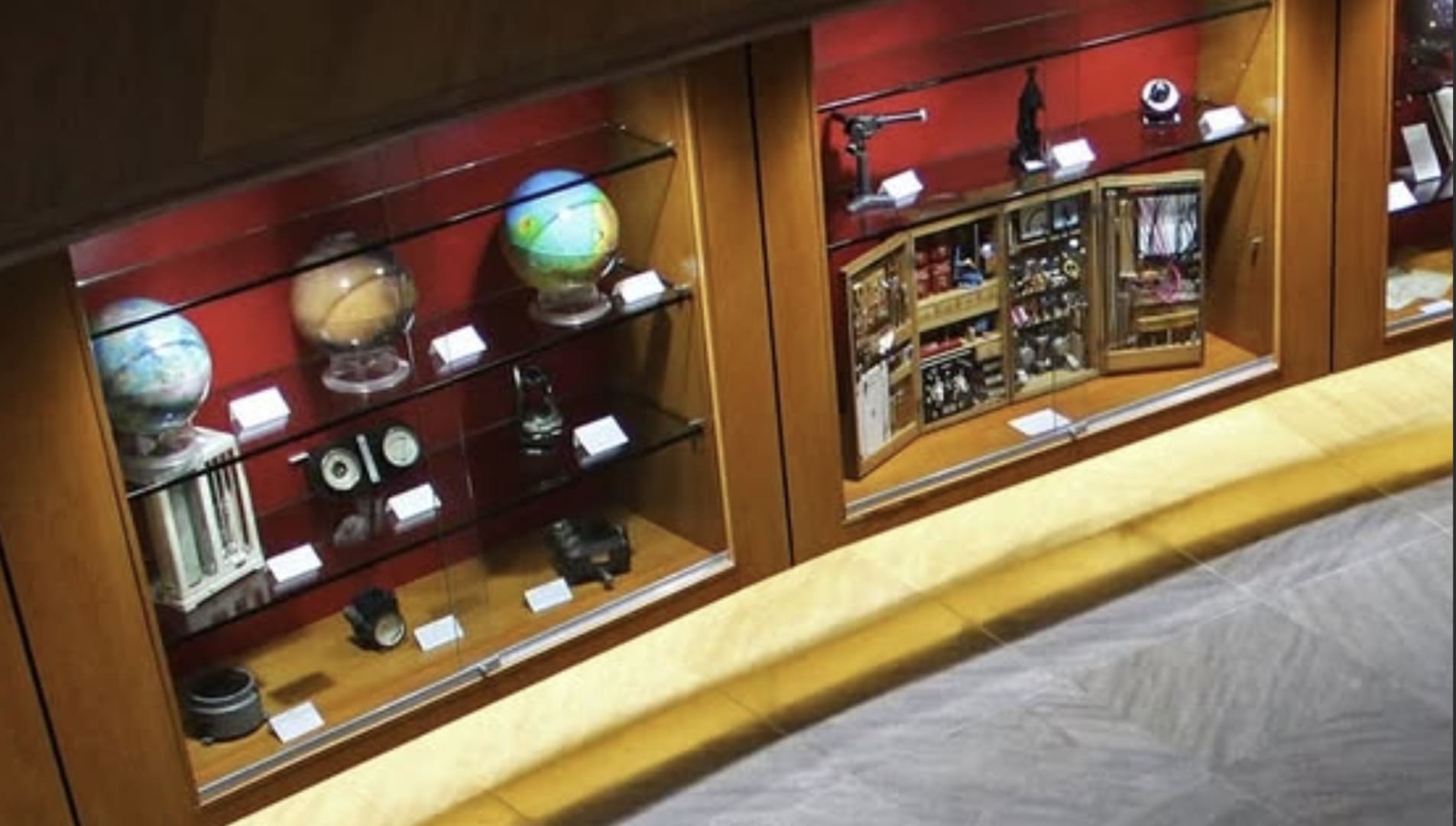Vitrines de museu exibindo globos terrestres e instrumentos astronômicos antigos