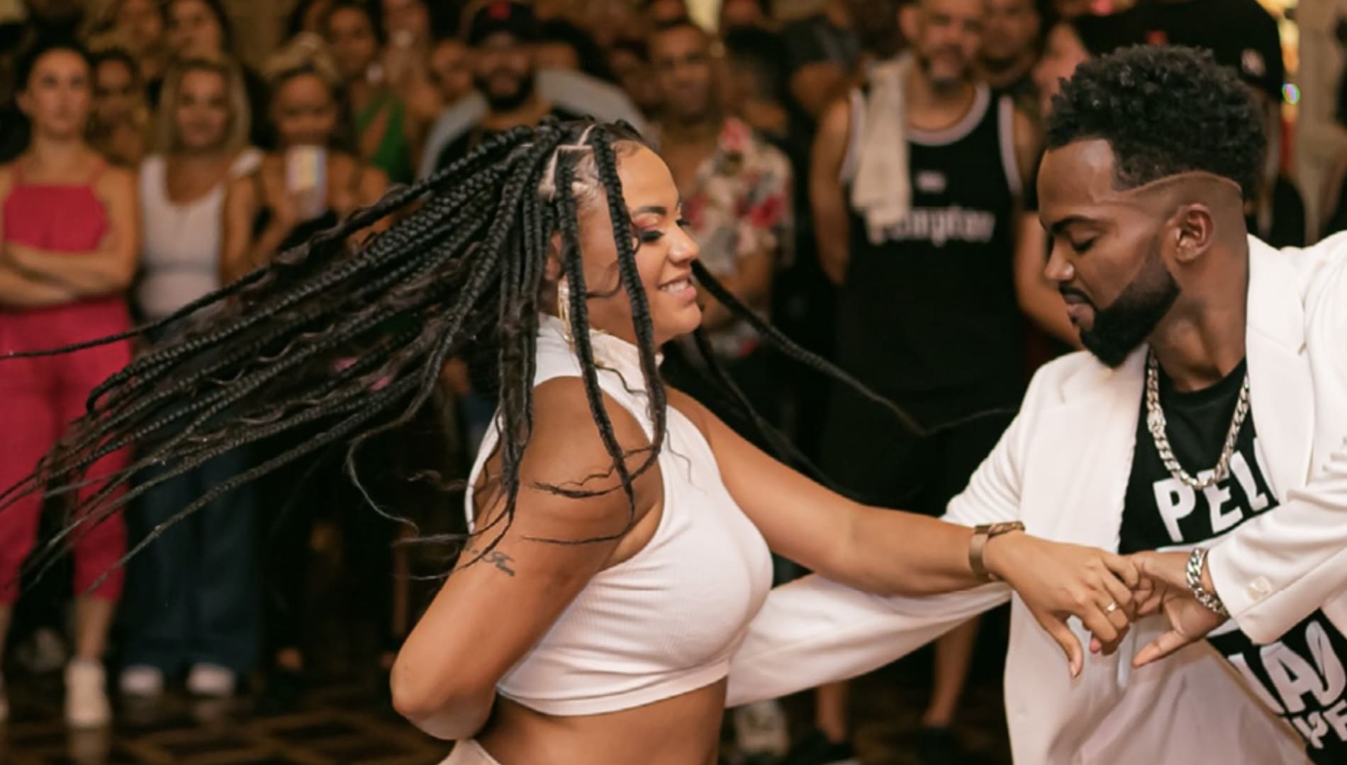 Criança de costas saltando em uma pista acrobática inflável dentro de um ginásio. No fundo, banners laranjas com o logotipo do Sesc e frases motivacionais.