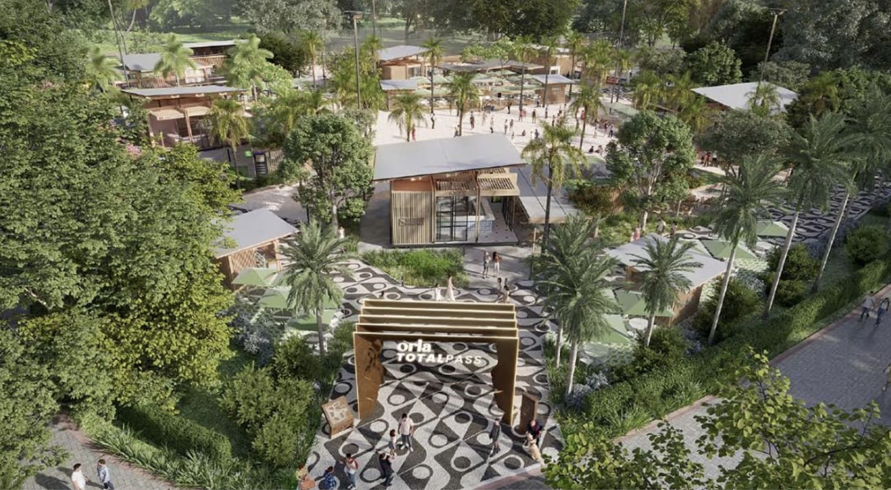 Vista aérea de uma renderização da Orla TotalPass em São Paulo, mostrando um complexo de lazer com diversos quiosques de madeira, palmeiras, áreas gramadas e caminhos pavimentados com mosaico preto e branco.