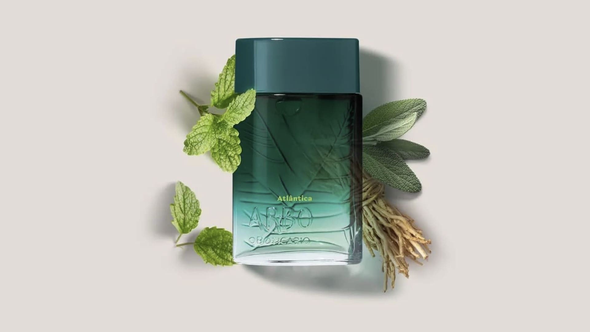 Frasco de perfume Arbo Atlântica em degradê de verde-escuro para azul-claro, decorado com folhas de hortelã, sálvia e raízes amadeiradas ao fundo.
