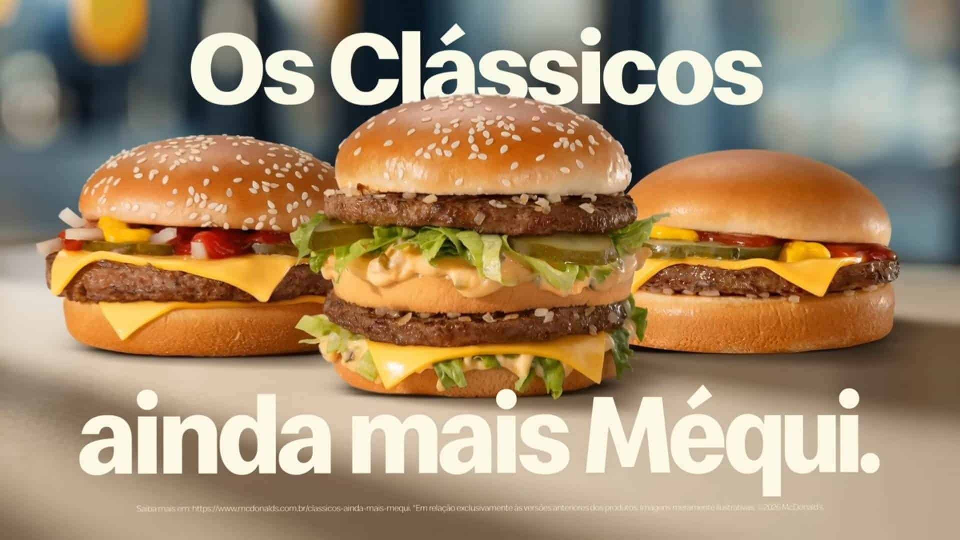 Três hambúrgueres clássicos do McDonald's alinhados sobre uma superfície clara, com o Big Mac em destaque no centro, sob a frase "Os Clássicos ainda mais Méqui".