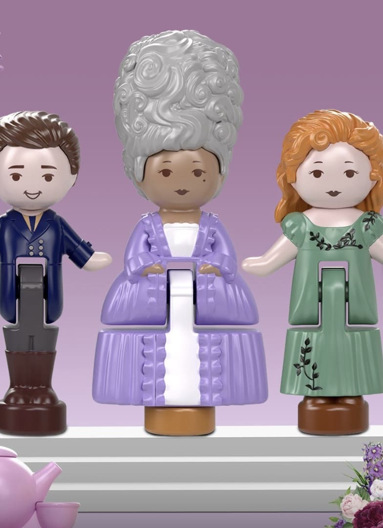 Três bonecos da linha Polly Pocket colecionável de Bridgerton: um homem com traje azul, a Rainha Charlotte com um grande penteado grisalho e vestido lilás, e Penelope Featherington com vestido verde.