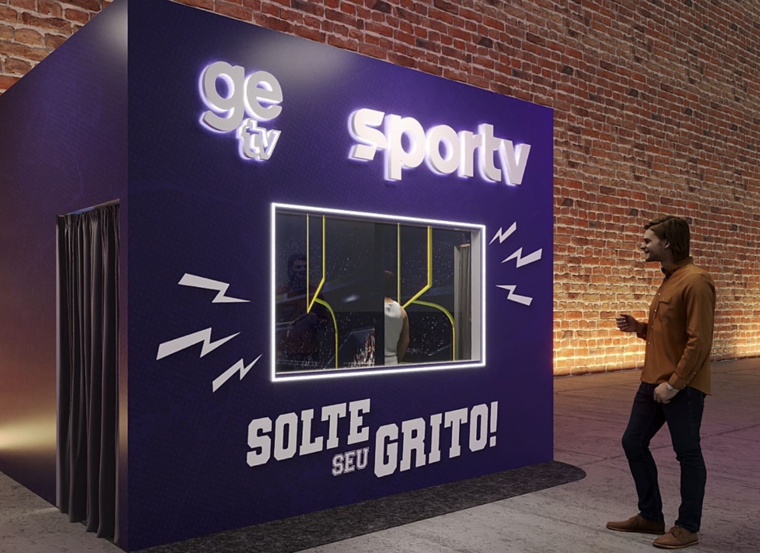 Estande roxo da "ge tv" e "sportv" com uma cabine de vidro e a frase "SOLTE SEU GRITO!", posicionado em frente a uma parede de tijolos com um homem ao lado.