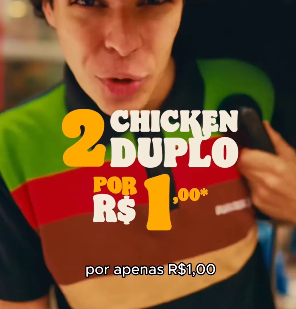 Close de um rapaz com o uniforme do Burger King, com um grafismo centralizado anunciando a promoção "2 Chicken Duplo por R$ 1,00". No rodapé, há uma legenda reforçando o valor de 1 real.