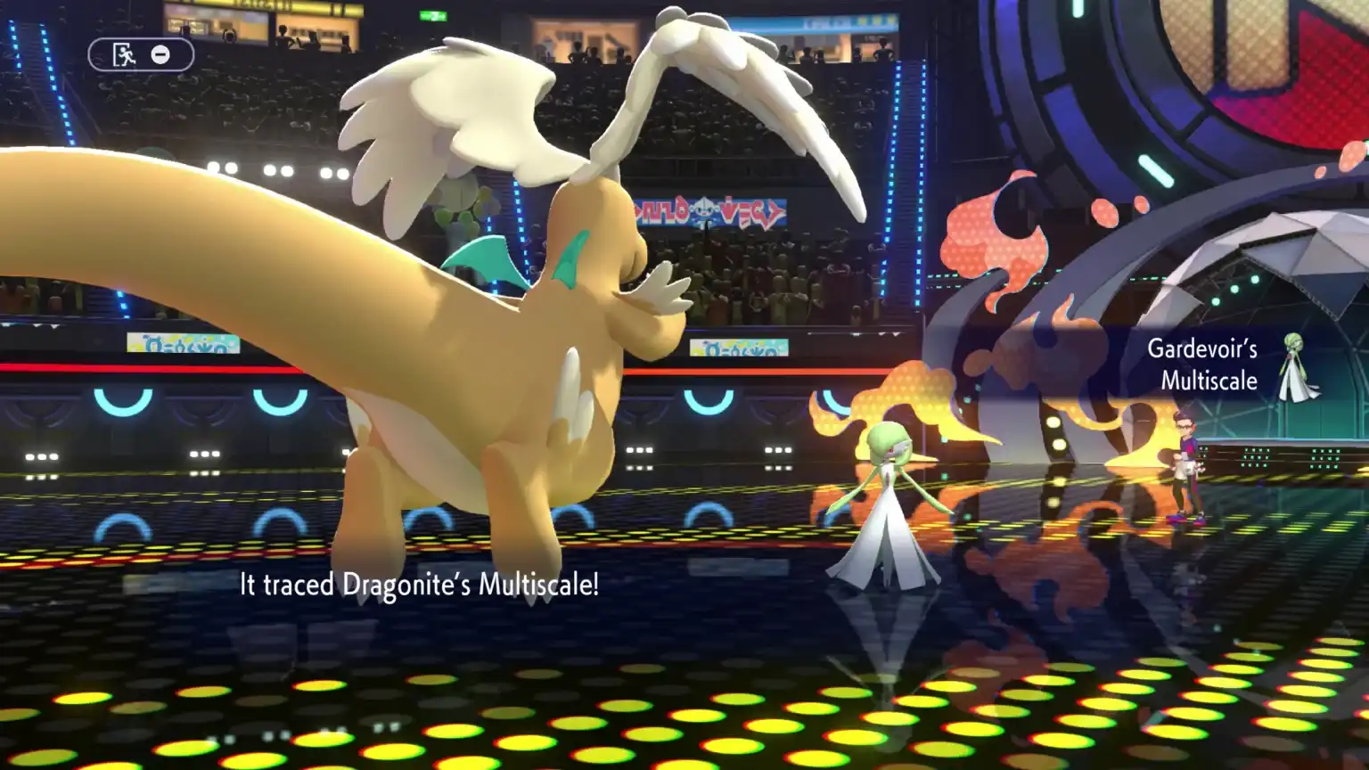 Uma captura de tela de uma batalha Pokémon em 3D, mostrando um Gardevoir em uma arena de discoteca iluminada por neon e o texto do jogo.