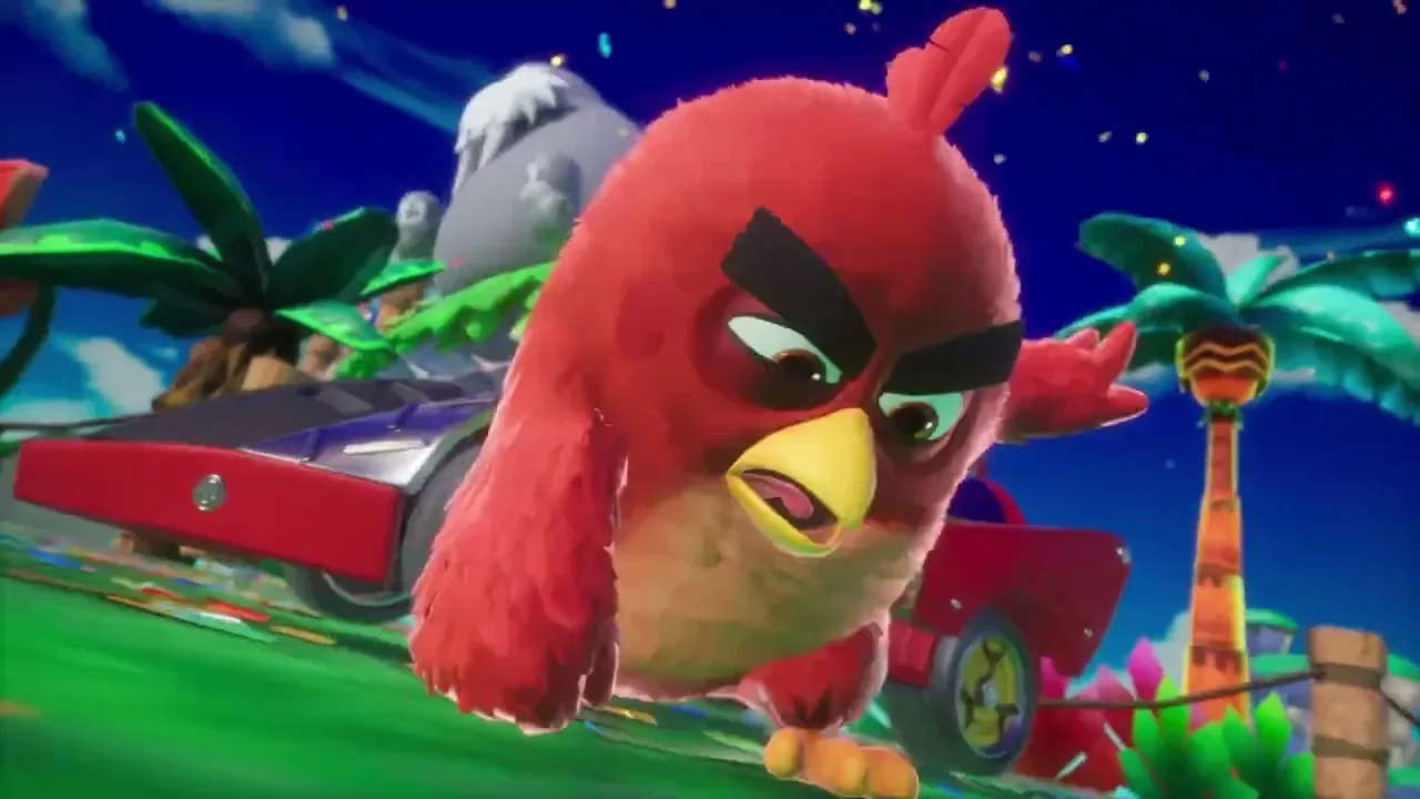 O personagem Red, de Angry Birds, em destaque em uma pista de corrida tropical à noite, com um carro de corrida vermelho e azul ao fundo.