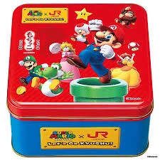 Uma imagem focada na lata de metal de edição limitada "Super Mario x JR Let's Go Kyushu", mostrando sua tampa vermelha vibrante e base azul. A tampa é ilustrada de forma elaborada com personagens do Super Mario e o logotipo da colaboração. A base azul tem uma placa amarela com o mesmo logotipo.