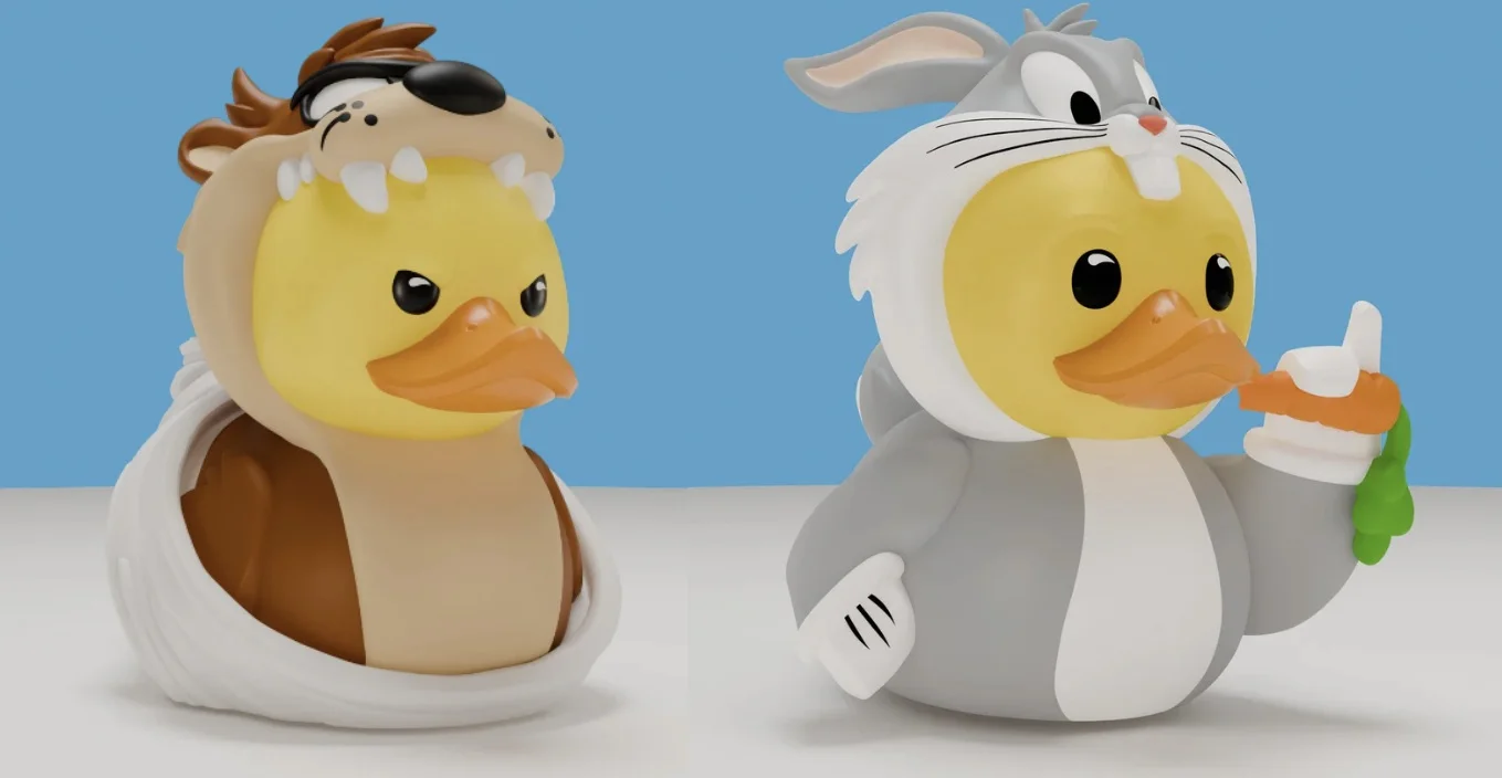 Dois patos de borracha colecionáveis vestidos com fantasias de Looney Tunes: um à esquerda como o Diabo da Tasmânia (Taz) e um à direita como Pernalonga segurando uma cenoura.