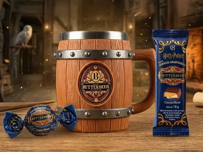 Close-up da caneca de ButterBeer da Cacau Show ao lado de um bombom e um tablete de chocolate da linha Harry Potter.