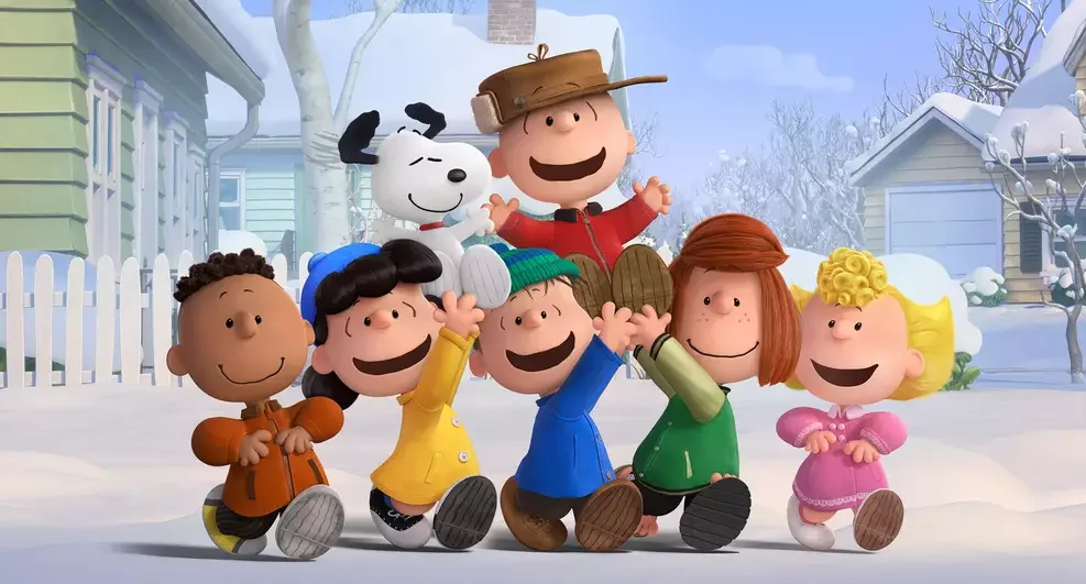 Charlie Brown, Snoopy, Lucy, Linus e o restante da turma posam sorridentes e agasalhados em um cenário de inverno coberto de neve.