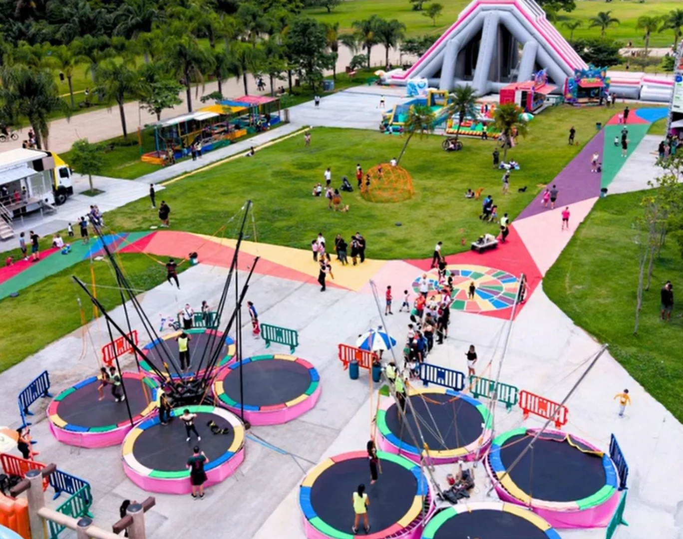 Vista aérea de uma área de recreação colorida com brinquedos infláveis e trampolins no Parque Villa-Lobos