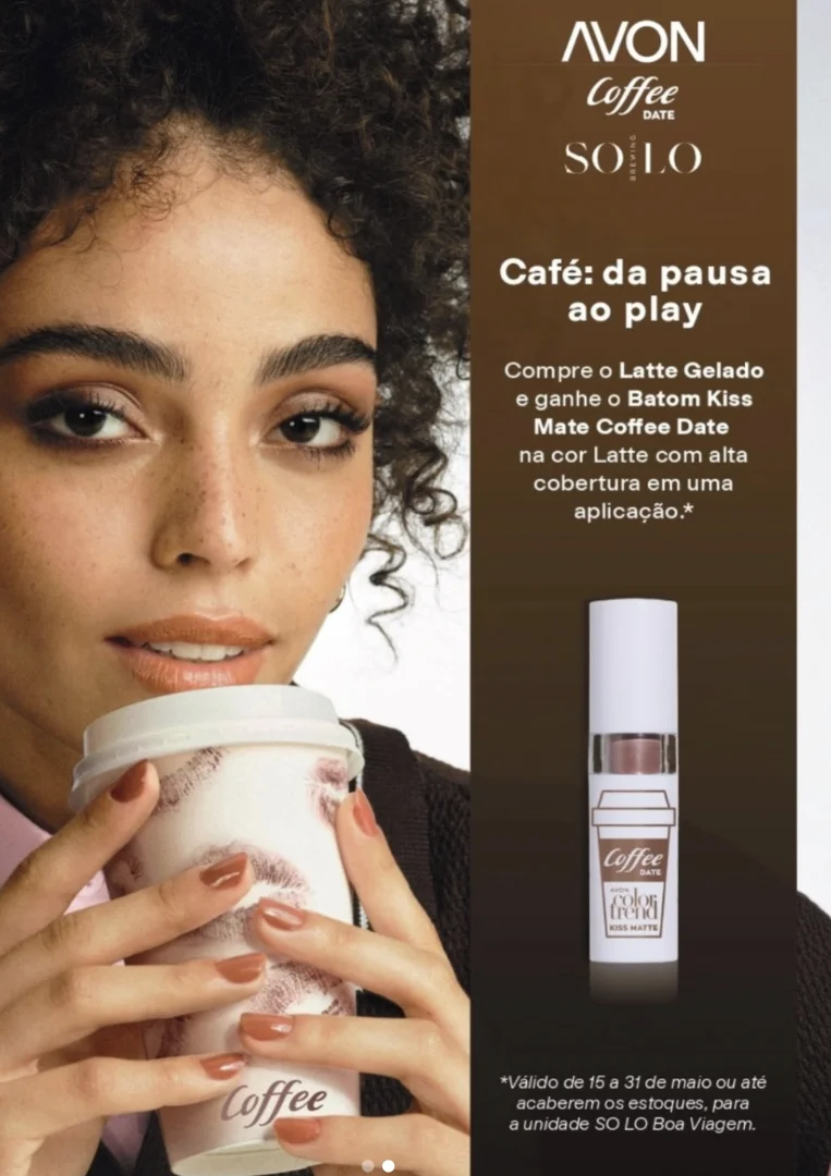 Mulher de cabelos cacheados segurando um copo de café com marcas de batom, ao lado de um anúncio da Avon Color Trend com a promoção do Batom Kiss Mate Coffee Date na cor Latte.