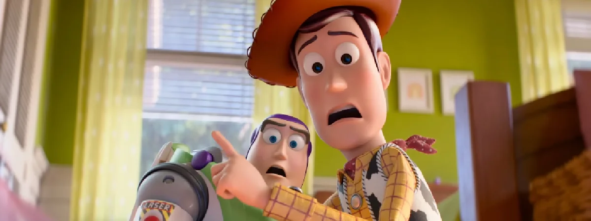 Close em Woody e Buzz Lightyear, de Toy Story, olhando para frente com expressões de extremo choque e pavor em um quarto ensolarado.