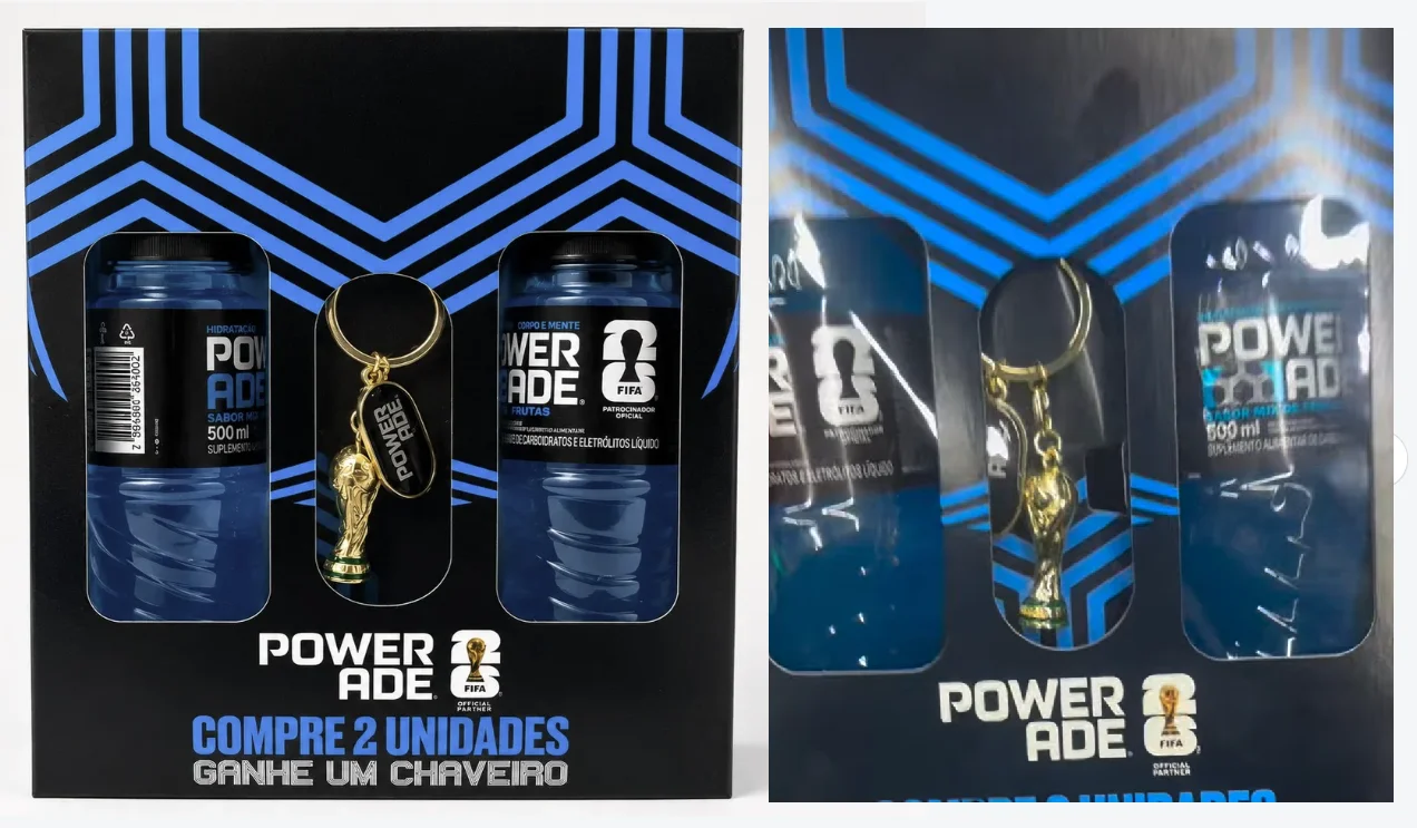 Embalagem promocional preta e azul da Powerade contendo duas garrafas da bebida e um chaveiro dourado da Taça do Mundo da FIFA no centro.