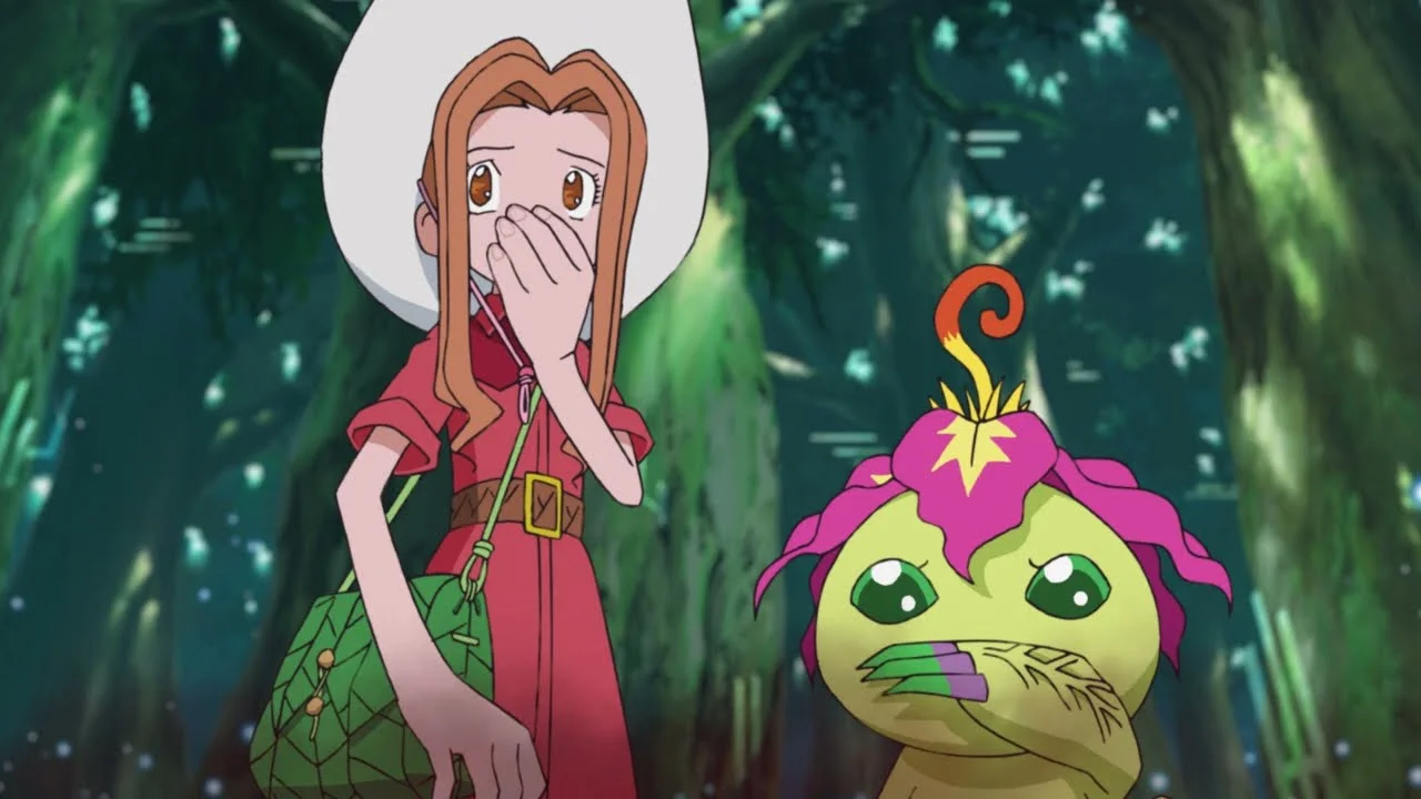 Close de Mimi e Palmon em uma floresta, ambas cobrindo a boca com as mãos em uma expressão de surpresa ou choque.