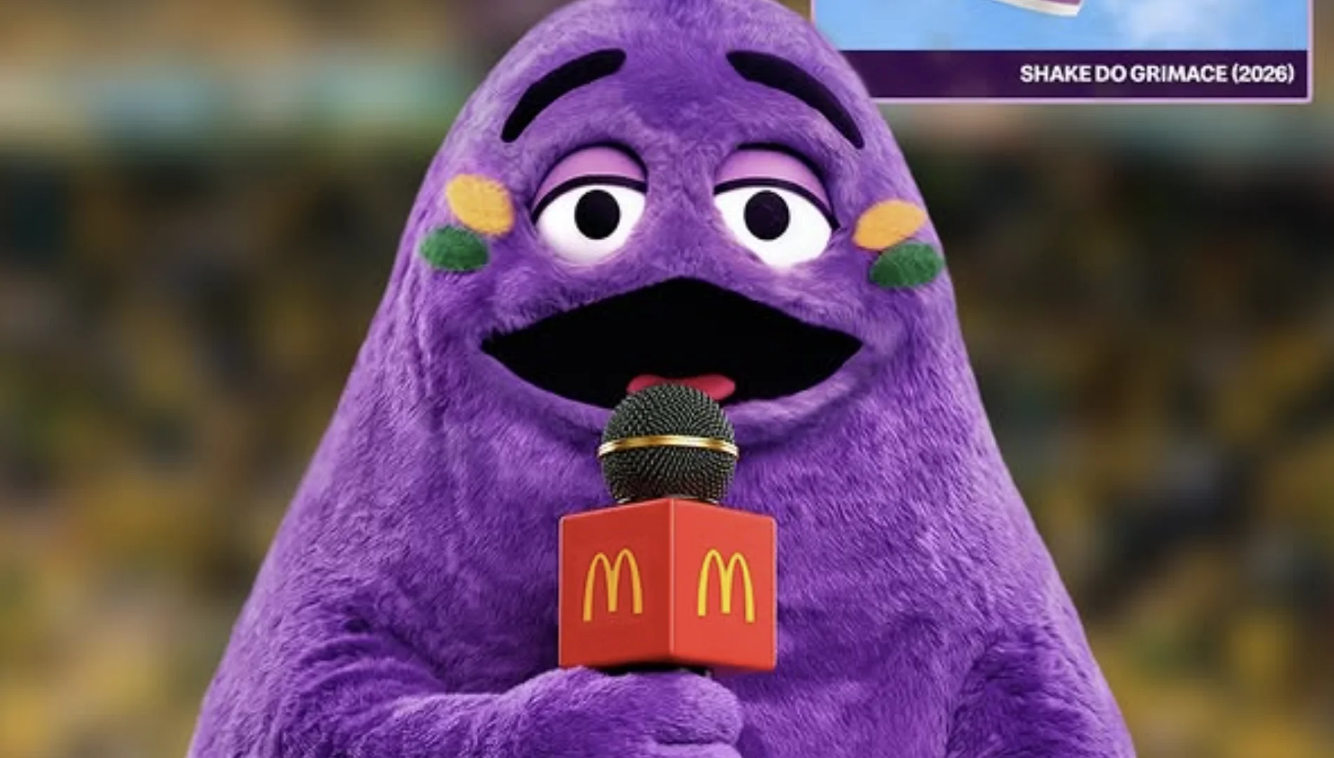 Close do personagem Grimace, do McDonald's, segurando um microfone de repórter com o logotipo da marca.