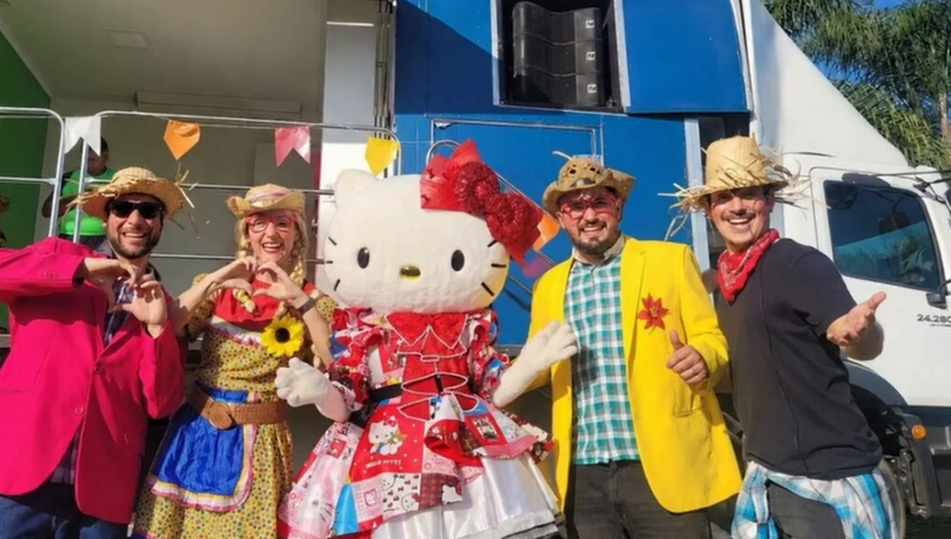 Hello Kitty posa com quatro pessoas fantasiadas de caipiras em frente a um trio elétrico no Parque Villa-Lobos