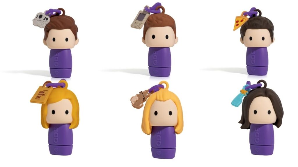 Catálogo com os seis batons colecionáveis da linha Friends organizados em duas fileiras sobre fundo branco, revelando os pingentes de cada personagem