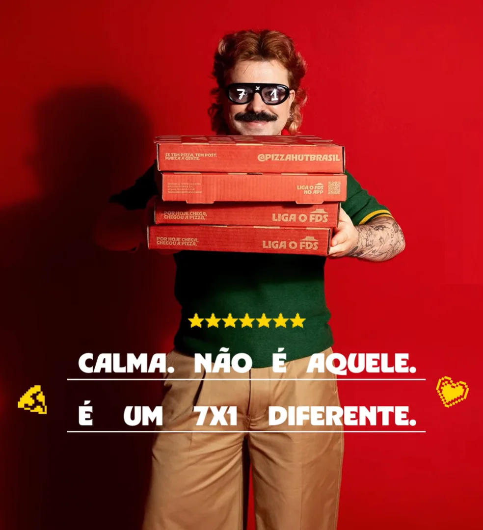 Homem com camisa verde segura várias caixas da Pizza Hut em fundo vermelho com frase “Calma. Não é aquele. É um 7x1 diferente”.