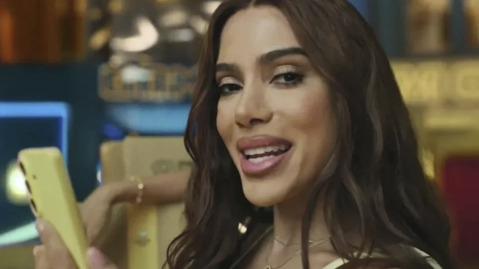 Cantora segura celular amarelo em cena de campanha do Mercado Livre.