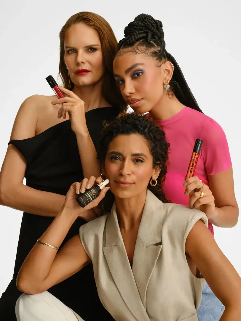 Três mulheres posam segurando produtos de beleza em campanha do Beautybox.