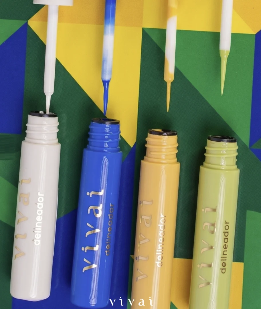 Delineadores líquidos coloridos da Vivai abertos com aplicadores destacados sobre fundo verde e amarelo.