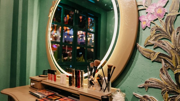 Espaço de maquiagem temático do São João com espelho iluminado, pincéis e produtos de beleza em ambiente decorado