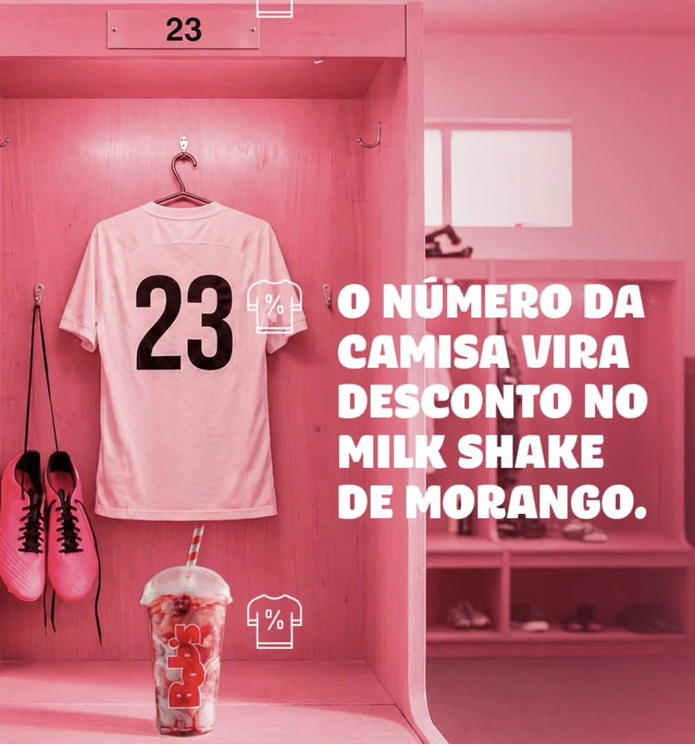 Armário de vestiário rosa com camisa número 23, chuteiras rosas e milk shake do Bob’s em campanha promocional.
