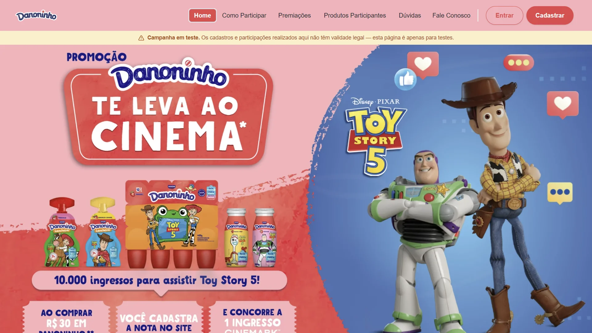 Captura de tela do site da campanha "Promoção Danoninho Te Leva Ao Cinema". O topo traz o menu de navegação e um aviso em destaque amarelo indicando "Campanha em teste". O banner principal é dividido entre um fundo rosa à esquerda — com embalagens ilustradas de Danoninho e os textos "Ganhe ingressos para assistir Toy Story 5!" e "Compre R$ 30, cadastre a nota e concorra" — e um fundo azul à direita, onde aparecem os personagens Woody e Buzz Lightyear ao lado do logotipo do filme Toy Story 5.