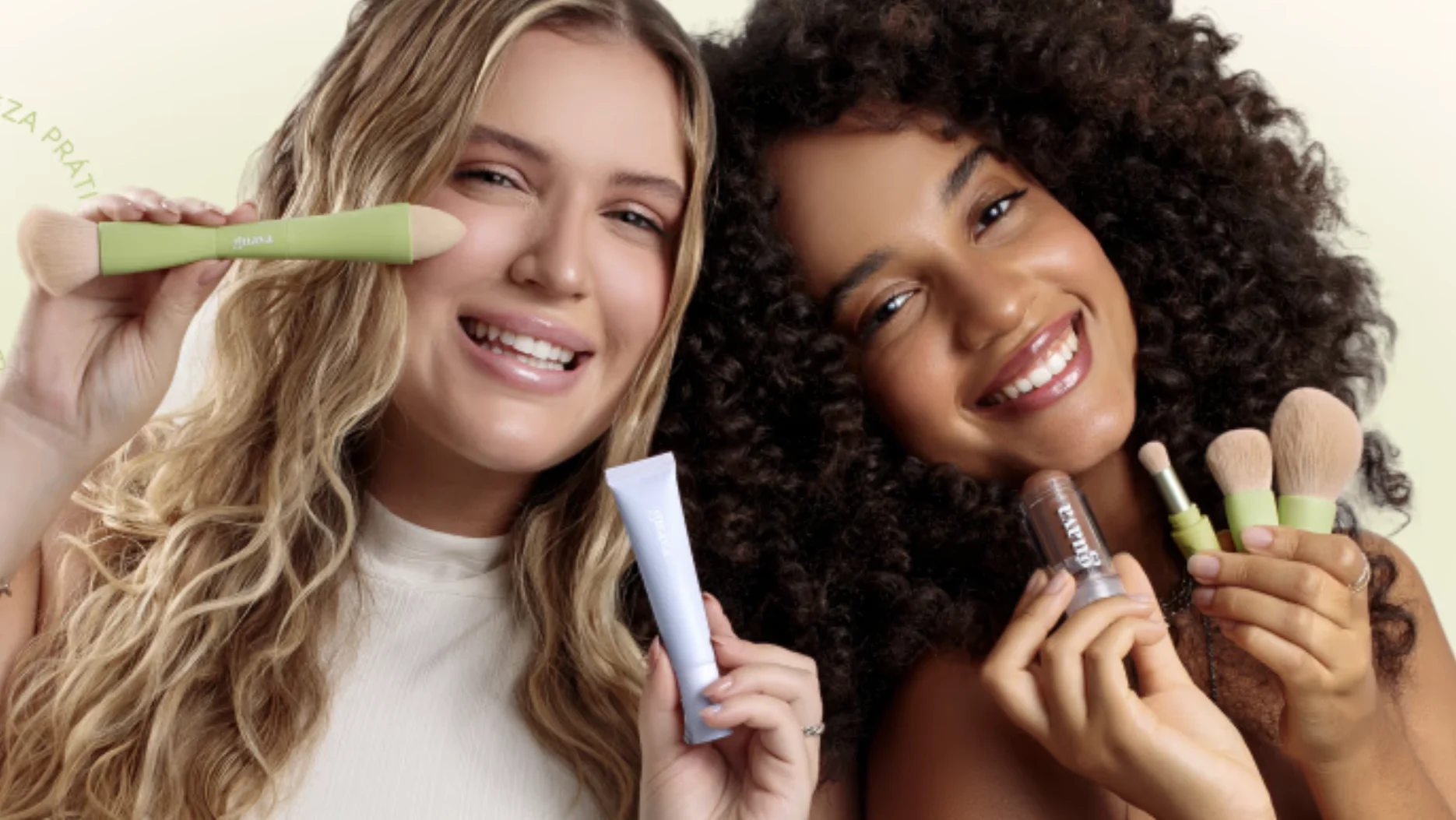 Duas criadoras de conteúdo posam sorrindo enquanto exibem produtos de maquiagem da Guava.