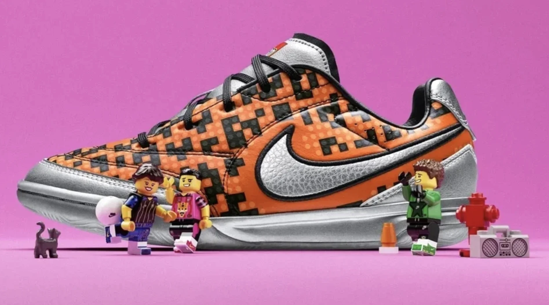 Tênis laranja e prata da Nike inspirado em LEGO aparece cercado por mini figuras e acessórios coloridos.