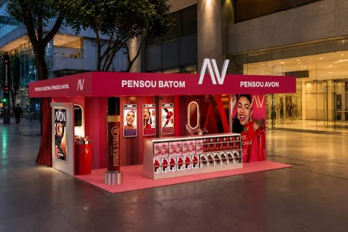 Estande da Avon montado no Shopping Cidade São Paulo com espaço para experimentação de batons e fotos durante ativação na Avenida Paulista.