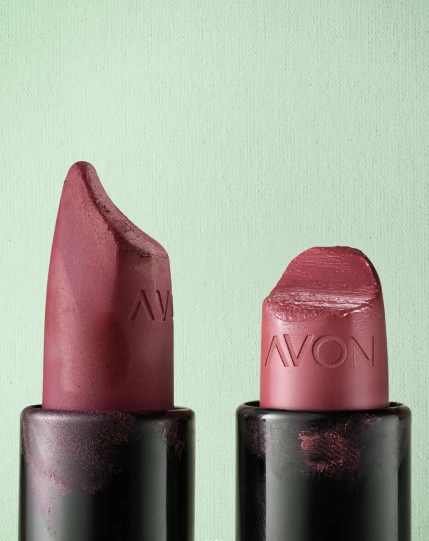 Dois batons Avon lado a lado, um novo e outro bastante usado, sobre fundo claro.