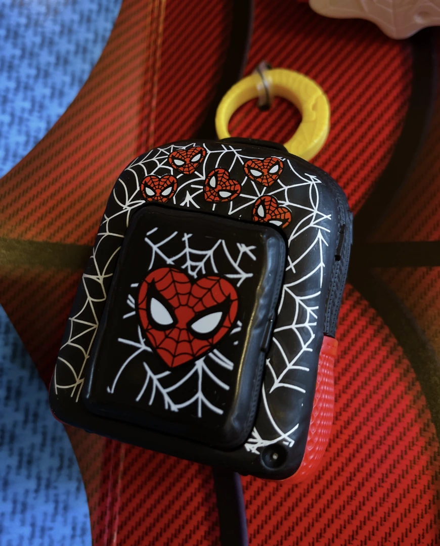 Mini mochila preta do Homem-Aranha, brinde do McLanche Feliz, com estampa de teias e rostos do herói em destaque.