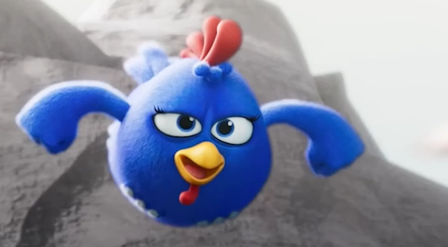 Galinha Pintadinha em versão 3D voando diante de uma montanha em cena do primeiro filme da franquia.