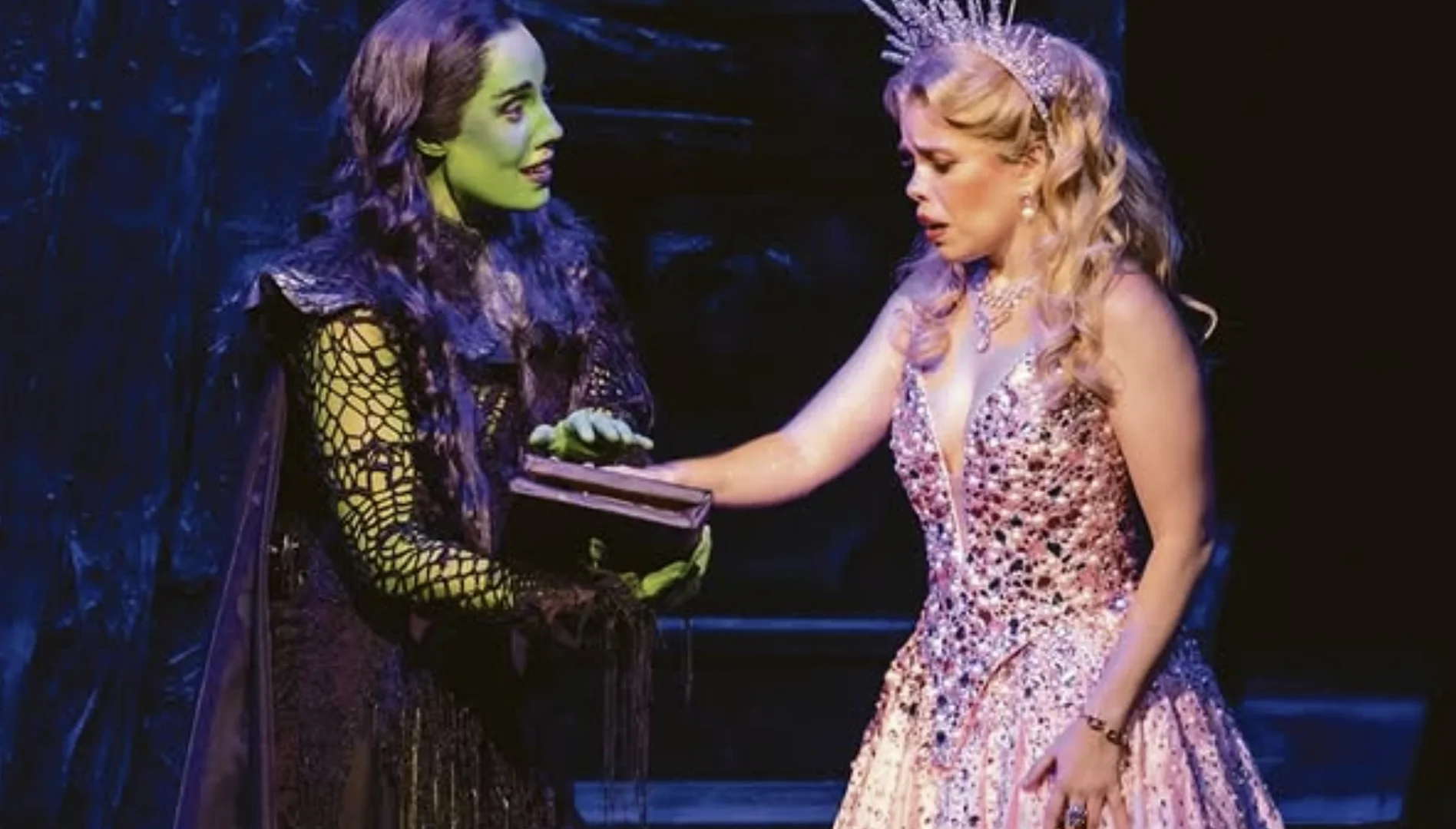 Atrizes caracterizadas como Elphaba e Glinda durante uma cena do musical Wicked no palco, em apresentação no Rio de Janeiro.