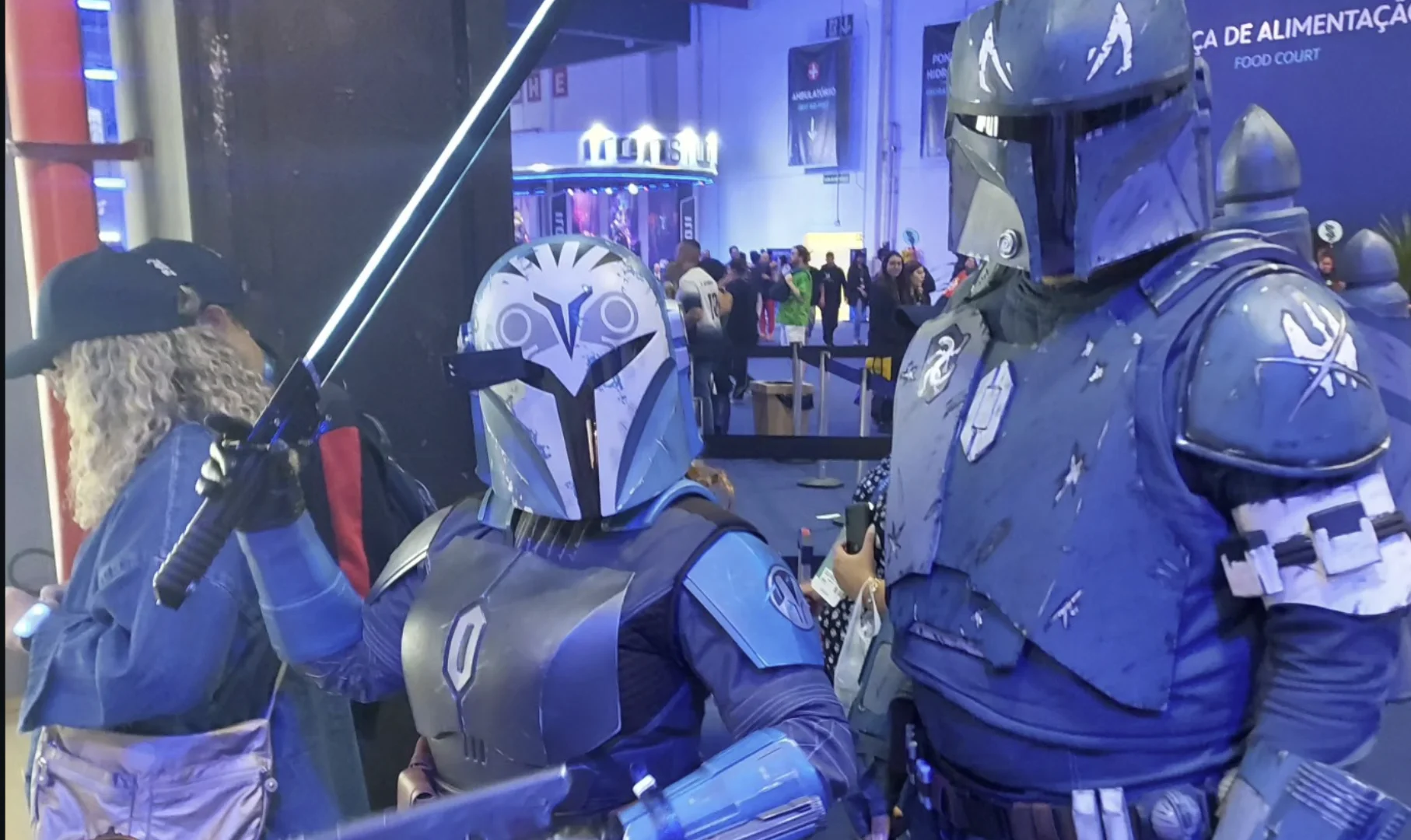 Cosplayers de Star Wars caracterizados como Mandalorianos durante a D23, em área de exposição do evento da Disney.