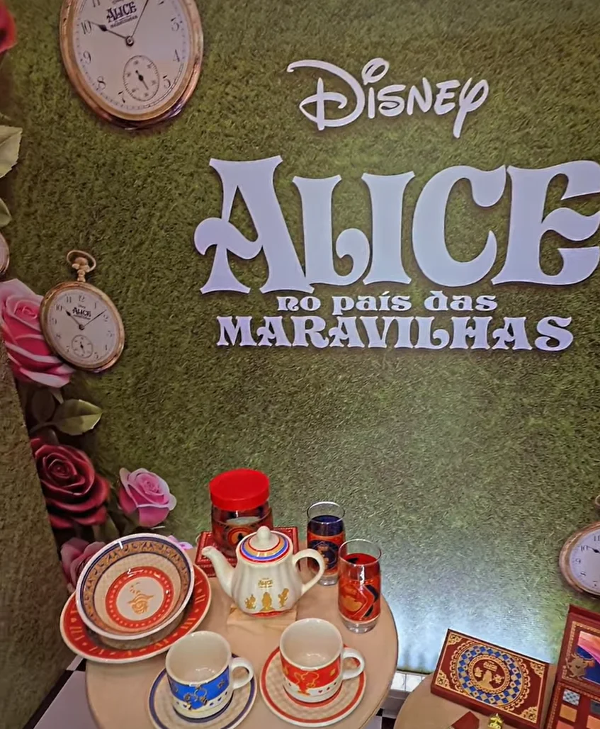 Coleção da Avon inspirada em Alice no País das Maravilhas com itens de maquiagem e decoração em exposição.